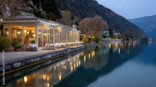 Serene Lakeside Restaurant at Dusk with Reflections on Water Surrounded by Mountains and Trees