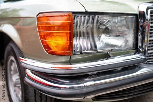 Headlight detail of vintage luxury car with chrome bumper and wiper