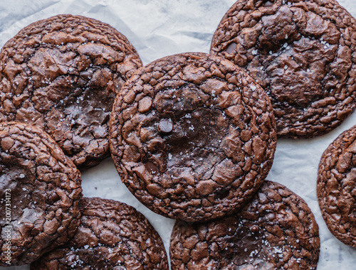 Close up of freshly baked chocolate brownie cookies on parchment.