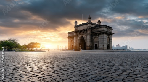 Majestic Gateway of India at Sunrise with Dramatic Clouds and Serene Landscape
