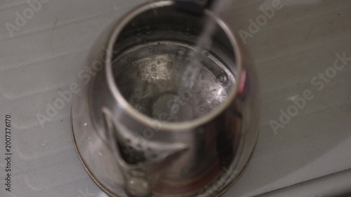Raw 4K footage of a steel utensil being washed under running water, showing cleaning process, hygiene, and daily kitchen routine in a simple household setting.