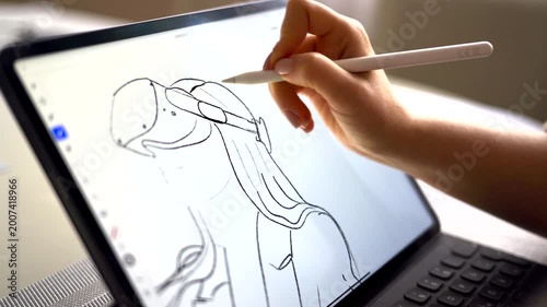 Digital artist drawing on tablet with stylus, creating concept art, close up on hand.