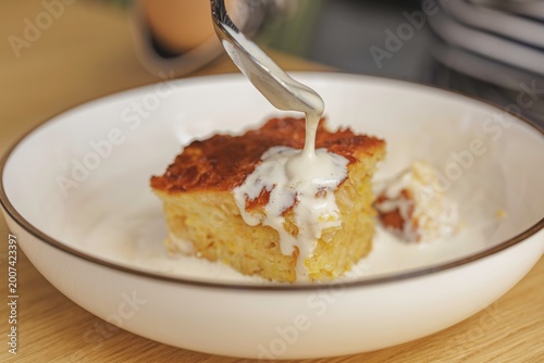Obraz na plátně A warm slice of a classic dessert is carefully drizzled with a rich, creamy sauce