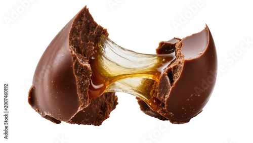 Фотография Broken chocolate candy with gooey caramel filling, isolated on transparent backg