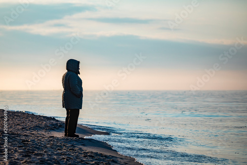 Foto A lonely pensioner's silhouette by the sea at sunset