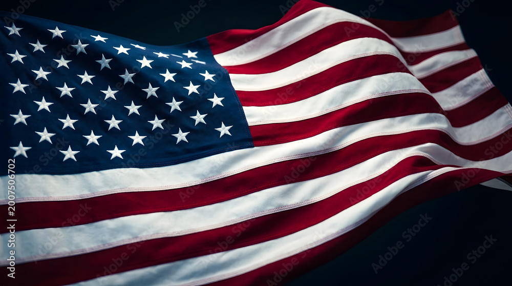 Obraz premium Majestic American flag waving proudly against a dark background, symbolizing freedom and patriotism.