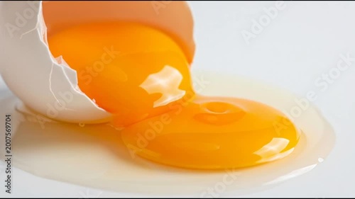 Broken raw egg yolk with cracked shell isolated on white background