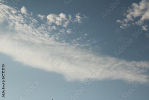 Fotografía Light, airy clouds scattered across a bright blue sky, creating a calm and minimal natural background with soft textures and peaceful atmosphere