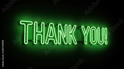 Green neon sign with the words thank you glowing against a dark black background for business appreciation.