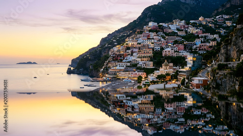Positano village reflected in calm water at sunset in Italy