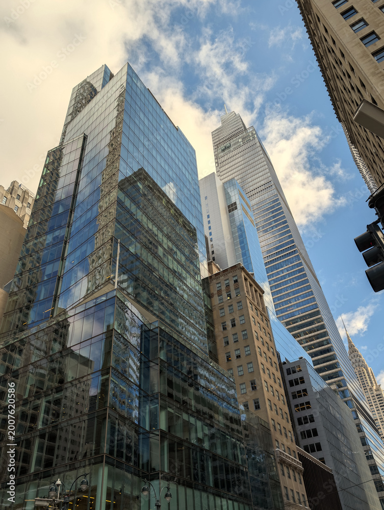 Fototapeta premium Majestic modern New York skyscrapers reflecting sunlight across iconic Manhattan skyline with towering architecture, urban atmosphere, and vibrant city energy, travel Usa