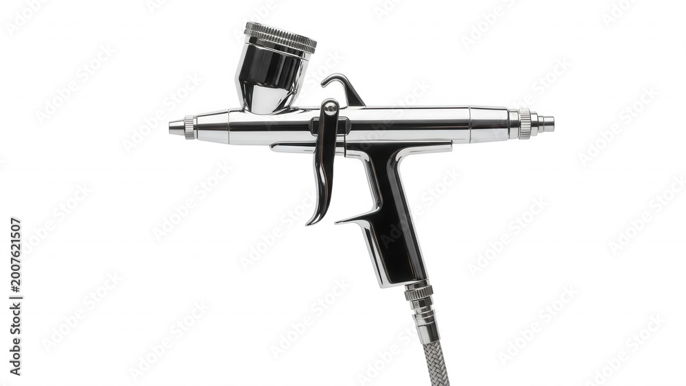 Naklejka premium A chrome airbrush tool with a top-mounted paint cup, isolated against a solid black background, showing metallic reflections and a trigger