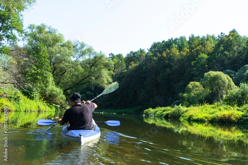 Family paddling a Vuoksa kayak on green rivers, family tourism and outdoor recreation.