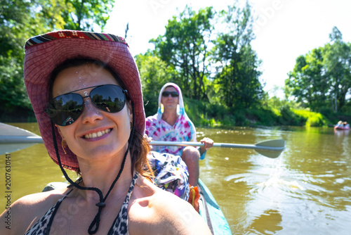 Εκτύπωση καμβά Young woman paddling kayak and taking selfie on river, recreational kayak trip, outdoor adventure gear, summer tourism and active lifestyle