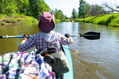 Photography Young woman in kayak with paddle, on the river, summer water tourism, recreational adventure, outdoor active lifestyle, travel equipment