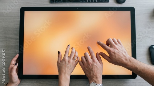 Fotografía Close-up of diverse hands interacting with a large touch screen display showing