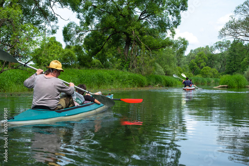 Back view of solo kayaker paddling through river, freedom, fitness, summer travel, adventure sport lifestyle tourism.