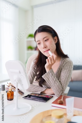 Принти на полотні young Asian women applying lipstick makeup cosmetics beauty routine sitting at t