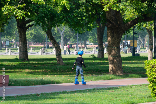Kid Wearing Helmet Skating on a Path in a Lush City Park