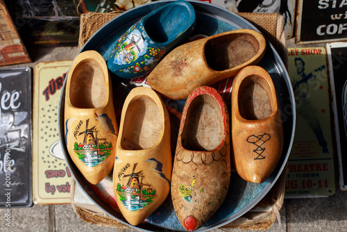 Photography Collection of vintage wooden clogs displayed in a round metal tray at an antique