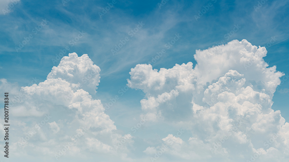 Fototapeta premium Panorama of fluffy white cumulus clouds on a clear blue sky, bright and airy natural background