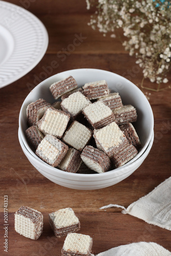 bowl com biscoito tipo waffer em cubos sobre mesa de madeira