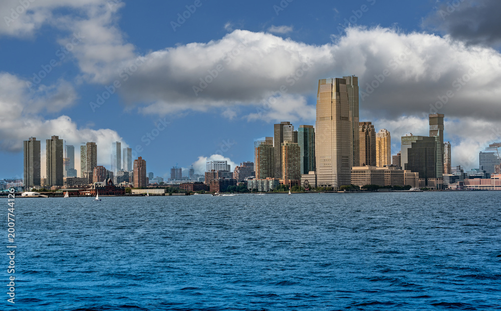 Obraz premium New york, usa august 16,2024. Manhattan skyline of new york city with towering skyscrapers along the hudson river on a cloudy day, panoramic waterfront view