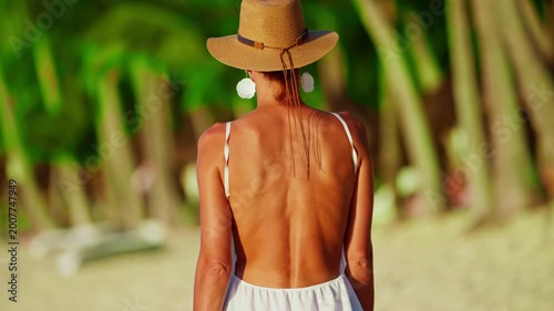 A concept of luxury vacation, freedom, beauty and tropical travel lifestyle. Ideal for summer promo content. View of woman walking along a tropical coastline. Mauritius