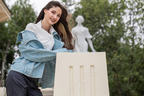 Portrait of a young beautiful brunette woman in a blue leather jacket