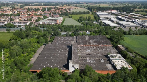 Fotografija Urban Landscape: An expansive aerial perspective captures a sprawling industrial complex, a residential neighborhood, and verdant surroundings