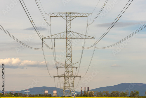 Fotografie Tall power lines stand in a flat area
