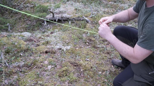 Primitive Camping Setup Using Rock to Fix Tent Stake Outdoors