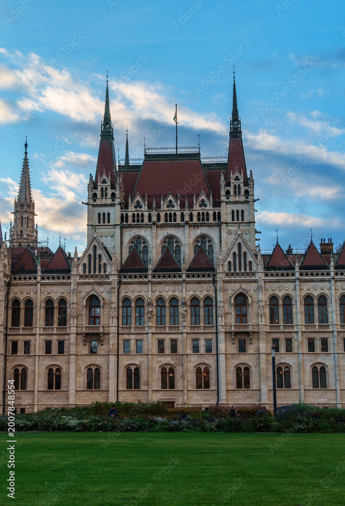 Fototapeta premium Magnificent Hungarian Parliament Building in Budapest under a beautiful blue sky with clouds during sunset featuring neo-gothic architecture and famous landmark details