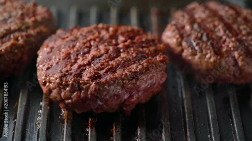 burger meat patties grilling on a barbecue grill. 
grilling hamburger beef patties on a grill.
burger meat patties roasting on a grill  beneath perfectly.