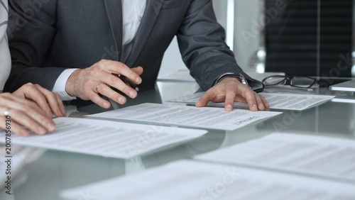 Business professionals discussing contract terms, lawyer explaining clauses, clients making agreements during a corporate meeting. Business people concept