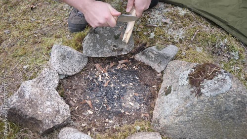 Hands Preparing Wood Shavings for Campfire in Stone Fire Pit