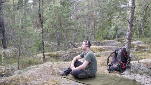 Hiker Resting with Headphones in Quiet Forest