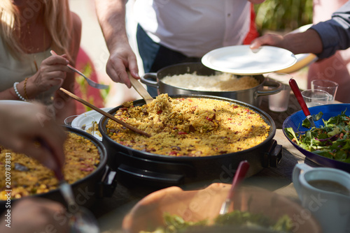 People Serving Paella and Rice at Outdoor Garden Party