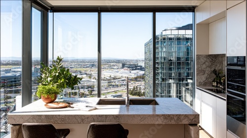 Modern kitchen island with sink overlooks city view from high rise.