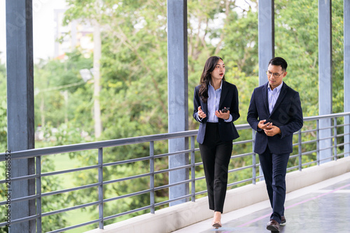 Business people walking and discussing work on skywalk