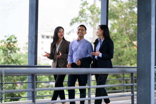Business colleagues walking and talking discussing work outdoors