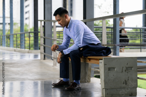 Photos Stressed businessman contemplating future while sitting on bench