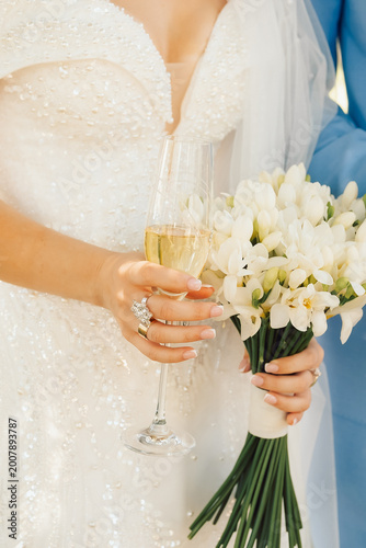 Quadro su tela Bride holding flowers and  glass of champagne in garden during wedding ceremony at daytime