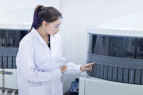 A laboratory pathologist using automatic multi slide stainer machine in a laboratory