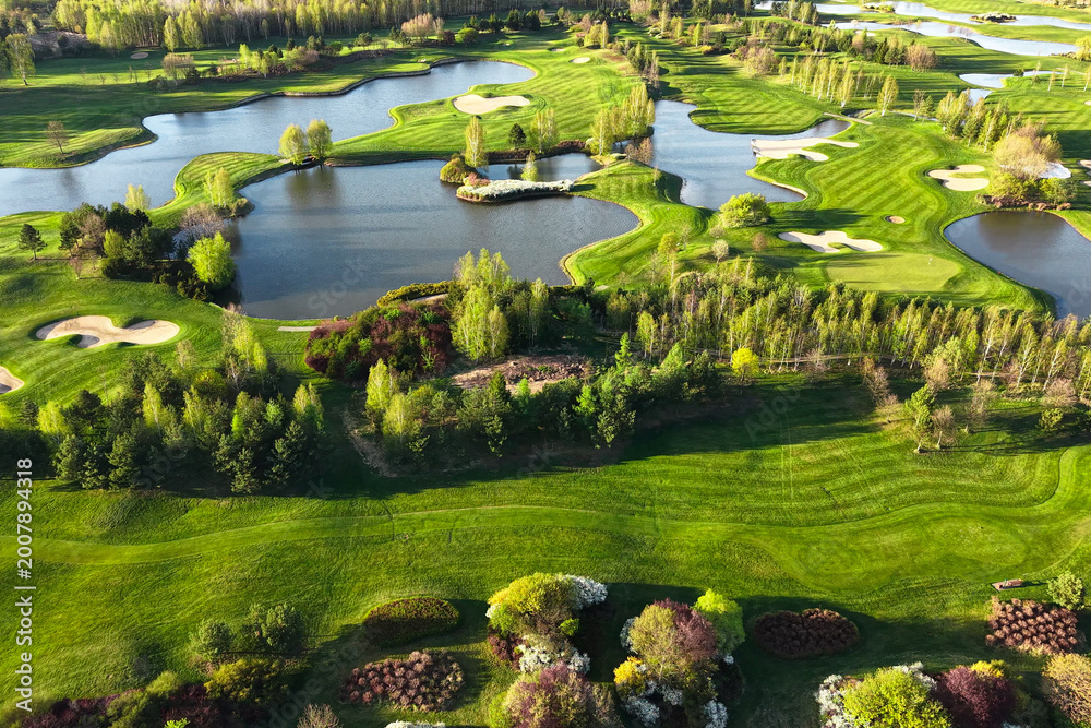 Fototapeta premium Panoramic golf course view with lakes and green forest