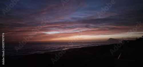Konstfotografi Sanfte Wellen am Strand bei einem lila Sonnenuntergang am Mittelmeer