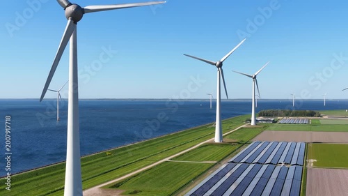 Aerial drone view of solar panels and wind turbines in a renewable energy farm. Sustainable green power station for clean electricity production and environmental technology infrastructure.
