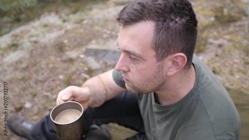 Man Holding Metal Cup While Resting Outdoors