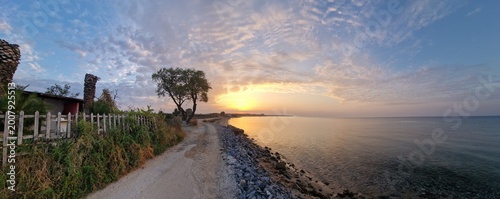 Konstfotografi Goldener Sonnenaufgang über dem ruhigen Meer mit sanfter Brandung