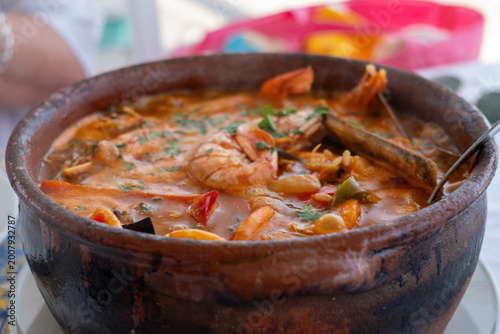 Obraz na płótnie Traditional Portuguese seafood rice served in a rustic clay pot with prawns
